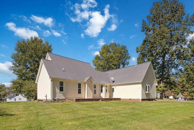 rear view of house featuring a lawn