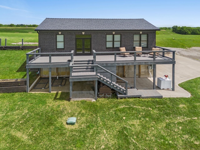 back of property with a deck, a lawn, and a patio area