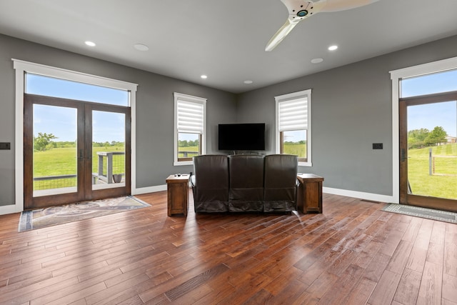 unfurnished living room with ceiling fan, a wealth of natural light, and dark hardwood / wood-style floors