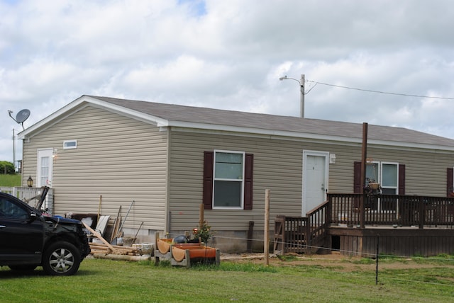 exterior space featuring a wooden deck and a lawn