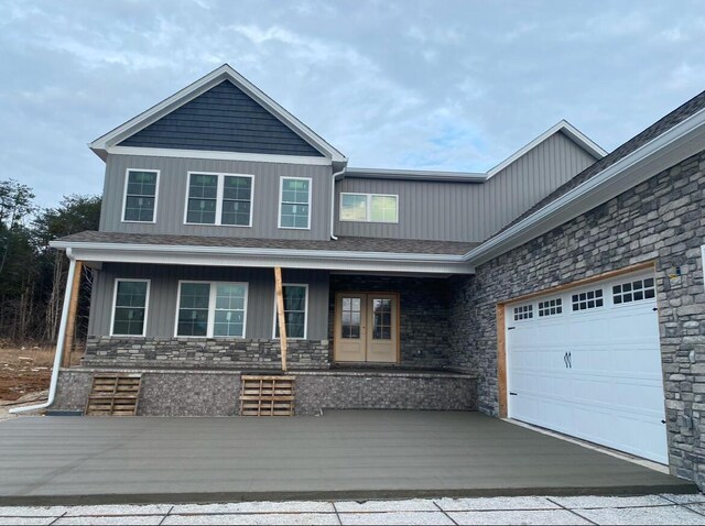 view of front of property with a garage, a front yard, and a porch