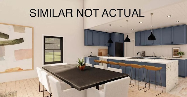 kitchen featuring backsplash, light wood-style flooring, a kitchen island, a sink, and blue cabinets