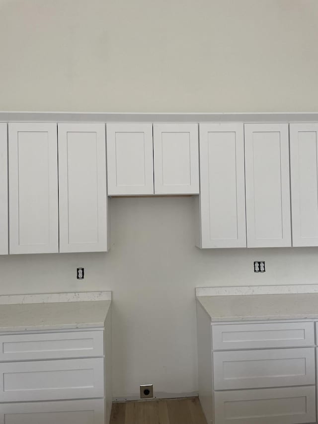 interior space with light countertops, wood finished floors, and white cabinetry