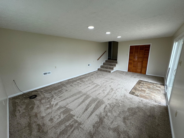 interior space featuring carpet flooring and a textured ceiling