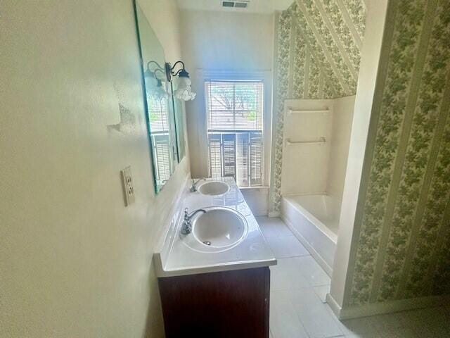 bathroom with tile flooring, shower / bathtub combination, vanity with extensive cabinet space, and double sink