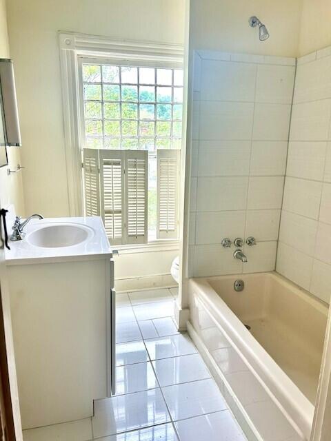 full bathroom featuring tiled shower / bath, vanity, and tile floors