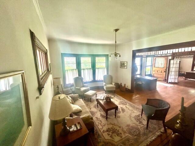 living room with ornamental molding and an inviting chandelier