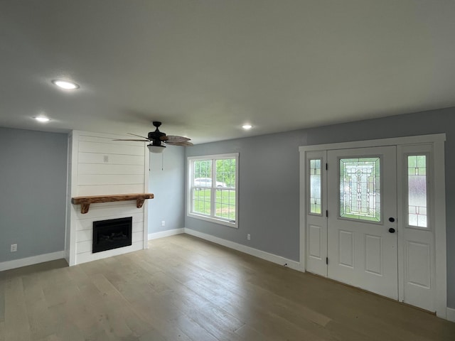 entrance foyer featuring a large fireplace, ceiling fan, and light hardwood / wood-style flooring