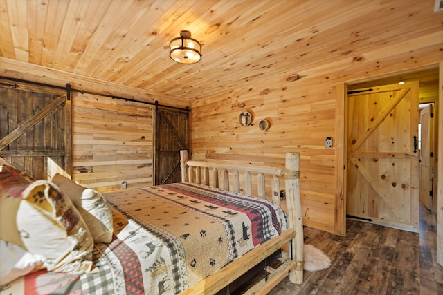 bedroom with a barn door, wooden walls, hardwood / wood-style floors, and wooden ceiling