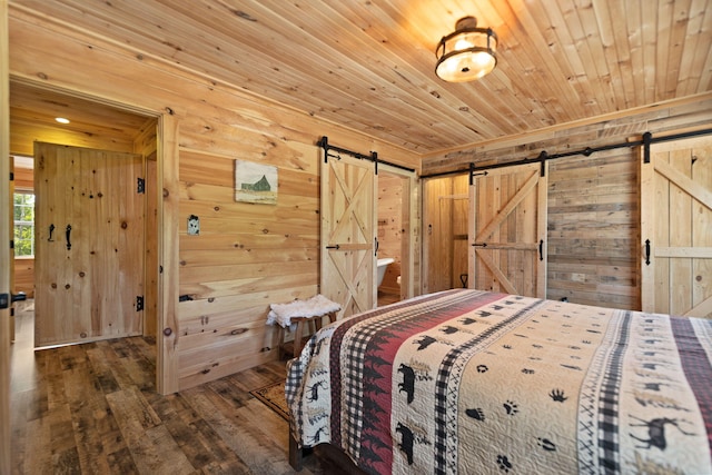 unfurnished bedroom with a barn door, wooden walls, dark hardwood / wood-style flooring, and wooden ceiling