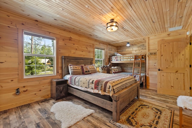 bedroom with wood walls, multiple windows, hardwood / wood-style floors, and wooden ceiling