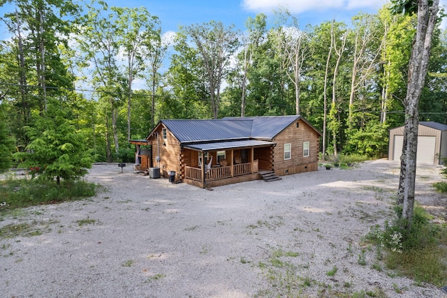 view of front of home with a garage, an outdoor structure, and covered porch