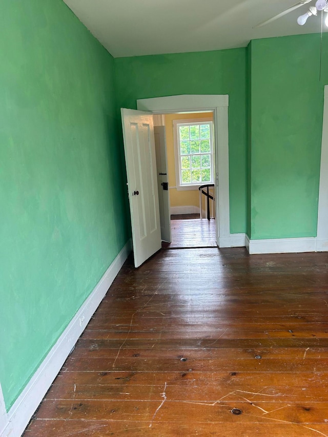 spare room with dark wood-type flooring and ceiling fan