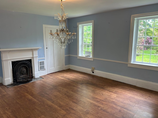 unfurnished living room with hardwood / wood-style floors, plenty of natural light, and a chandelier