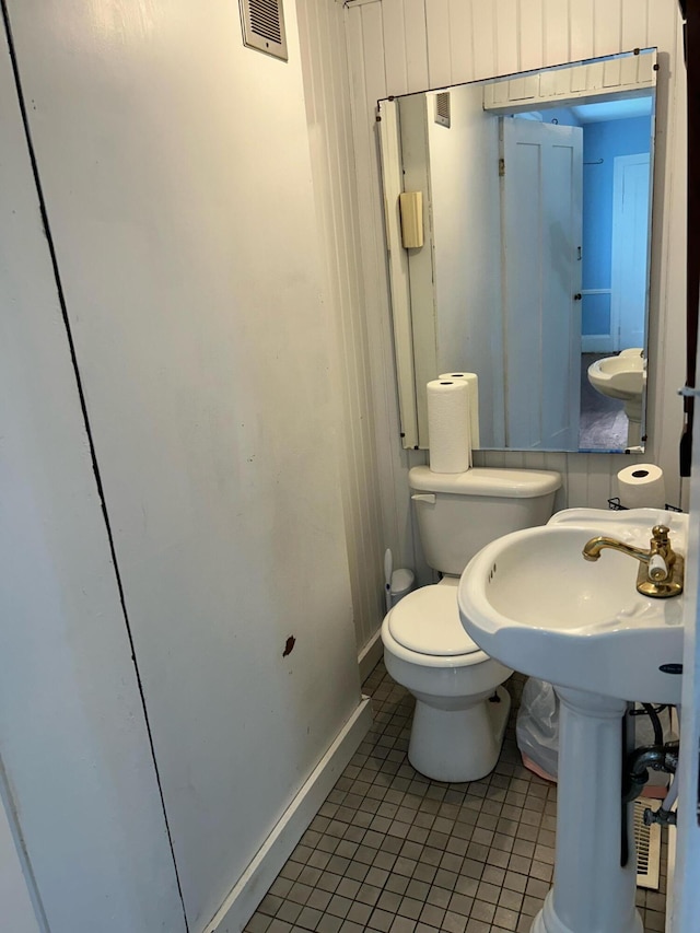 bathroom featuring tile flooring and toilet