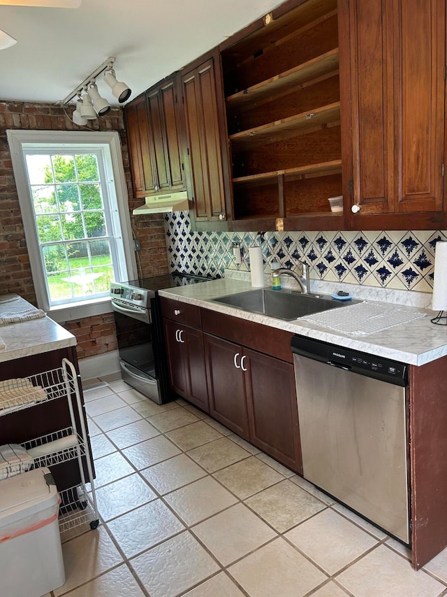 kitchen with stainless steel appliances, light tile flooring, track lighting, and backsplash