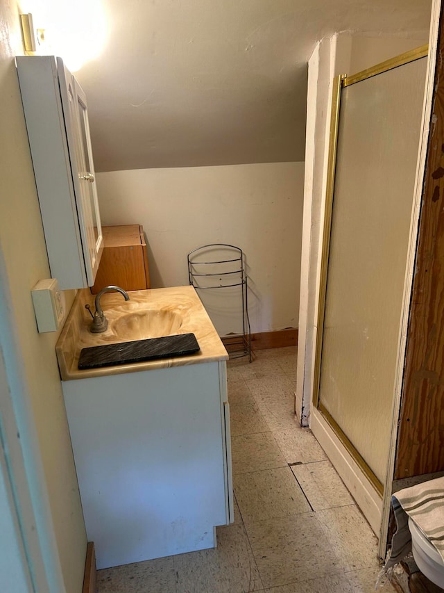 bathroom featuring tile floors, a shower with shower door, and vanity