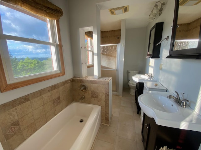 bathroom featuring tile patterned floors, a washtub, vanity, and toilet