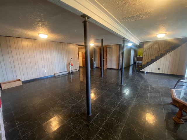 basement featuring a textured ceiling and dark tile patterned floors