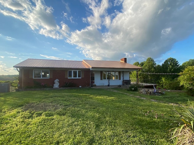 rear view of property featuring a yard, cooling unit, and a porch