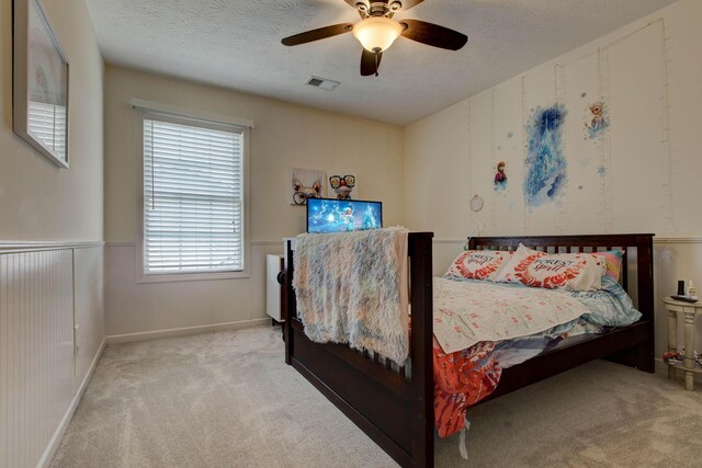 bedroom featuring a textured ceiling, ceiling fan, and carpet flooring