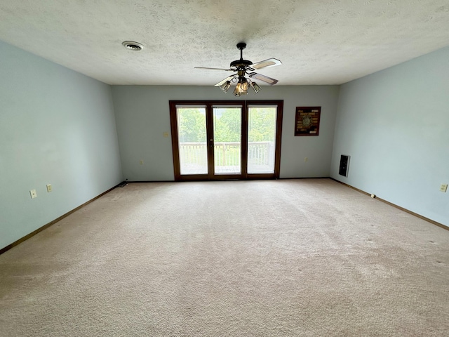 carpeted spare room featuring a textured ceiling and ceiling fan