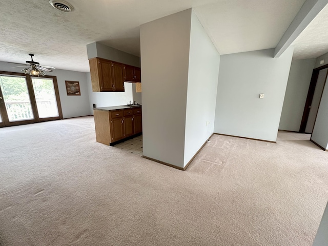 carpeted empty room with ceiling fan and a textured ceiling