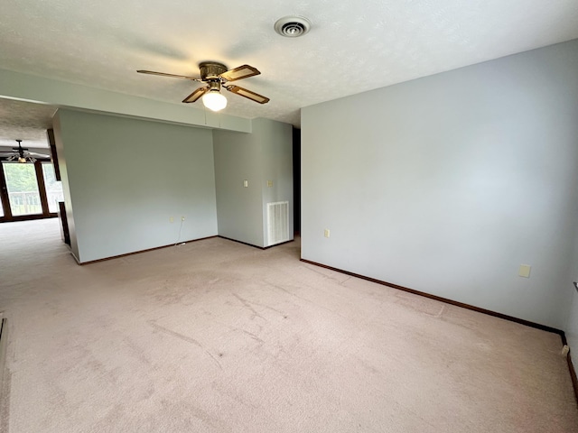 carpeted spare room with a textured ceiling and ceiling fan