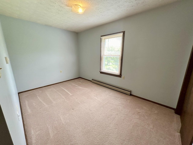 spare room featuring carpet flooring, a baseboard heating unit, and a textured ceiling