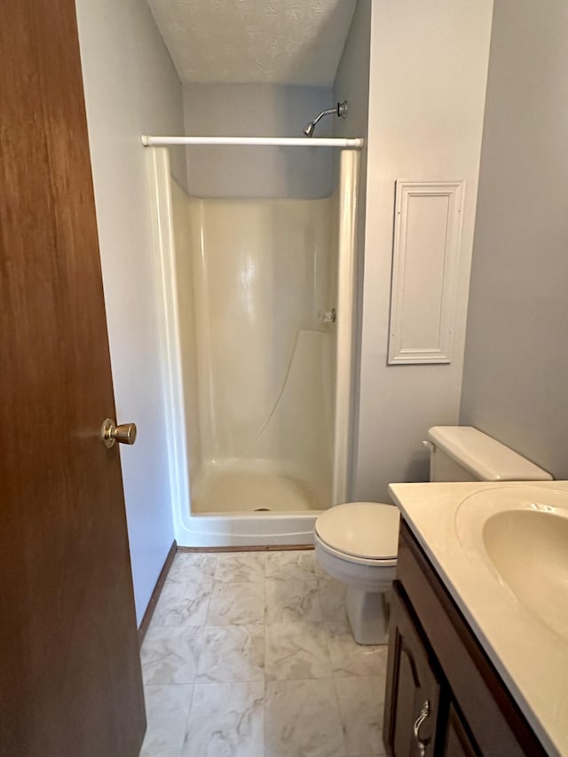 bathroom featuring a textured ceiling, walk in shower, tile floors, toilet, and vanity