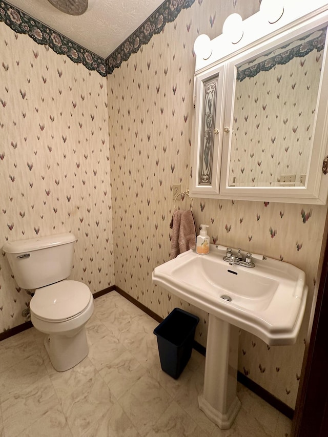 bathroom featuring toilet, tile flooring, and a textured ceiling