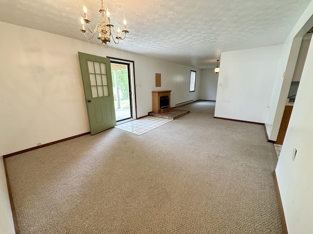 spare room with an inviting chandelier, carpet flooring, a baseboard radiator, and a textured ceiling