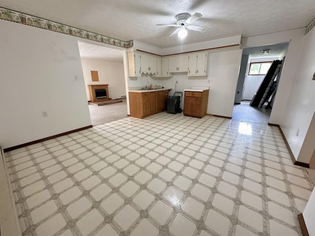 kitchen featuring white cabinets, a textured ceiling, ceiling fan, and light tile flooring