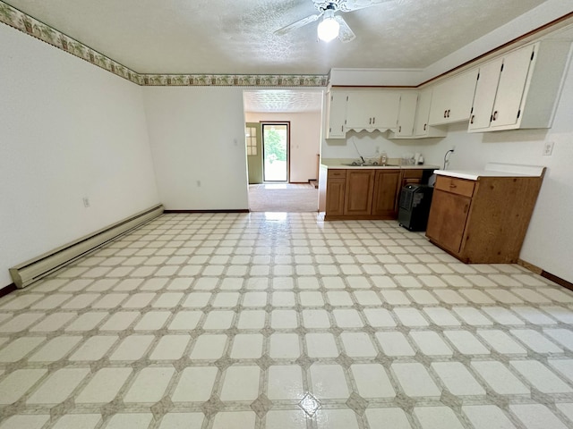 kitchen with a baseboard heating unit, ceiling fan, a textured ceiling, white cabinets, and light tile floors