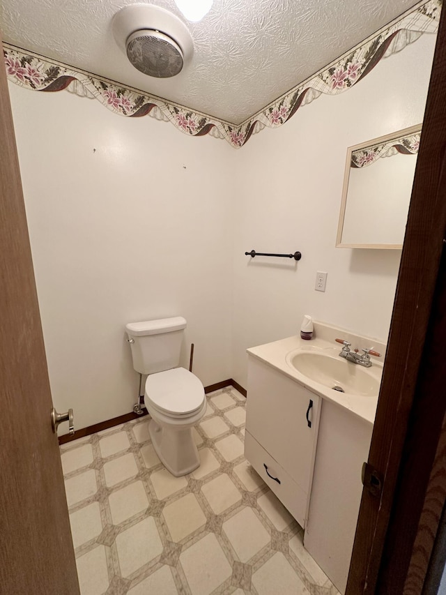 bathroom with toilet, tile floors, a textured ceiling, and large vanity