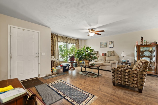 living room featuring ceiling fan and hardwood / wood-style flooring