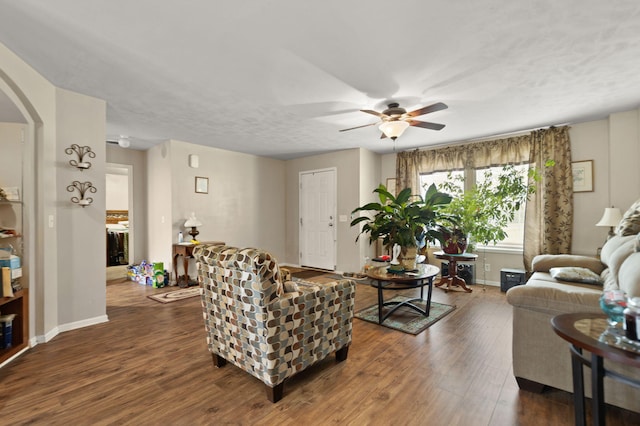 living room featuring ceiling fan and dark hardwood / wood-style flooring