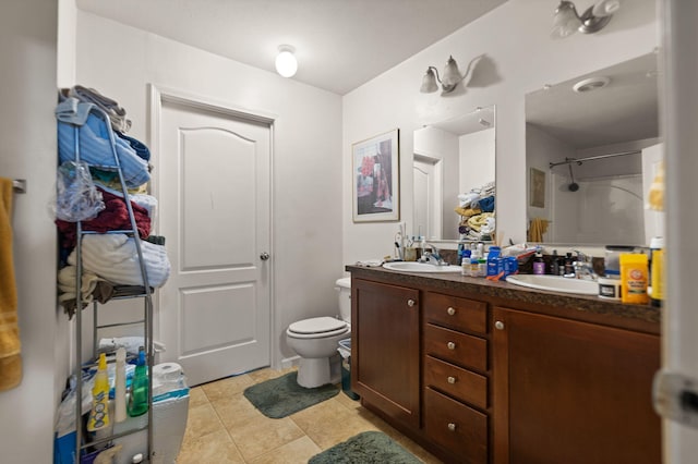 bathroom featuring a shower, toilet, vanity, and tile patterned flooring