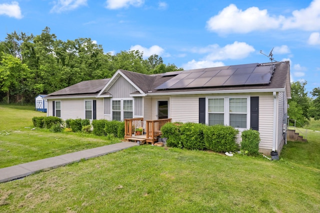 view of front of home featuring a front lawn, a storage shed, and solar panels