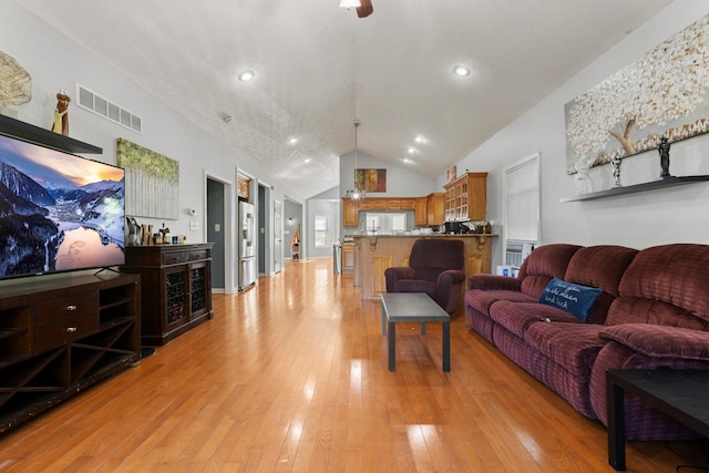 living room with light hardwood / wood-style flooring and vaulted ceiling