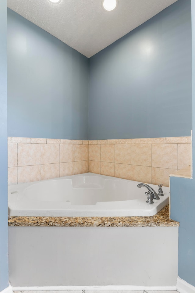 bathroom featuring a textured ceiling and a bathing tub