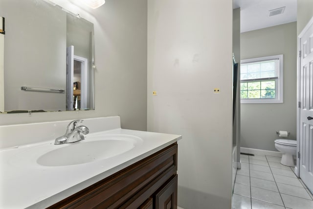 bathroom with tile floors, vanity, and toilet