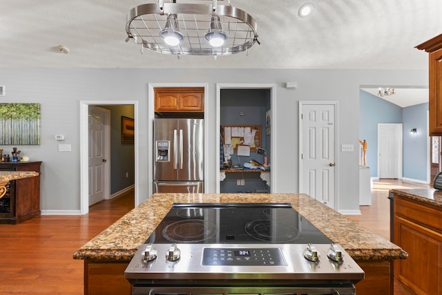 kitchen with a center island, light hardwood / wood-style flooring, and stainless steel fridge with ice dispenser