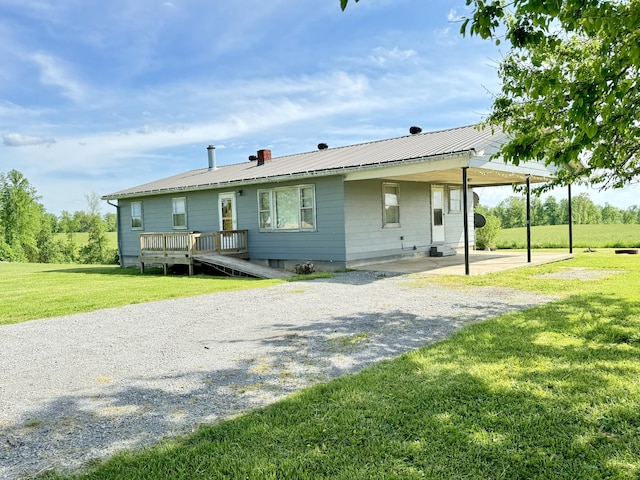 view of front facade featuring a carport, a front lawn, and a wooden deck