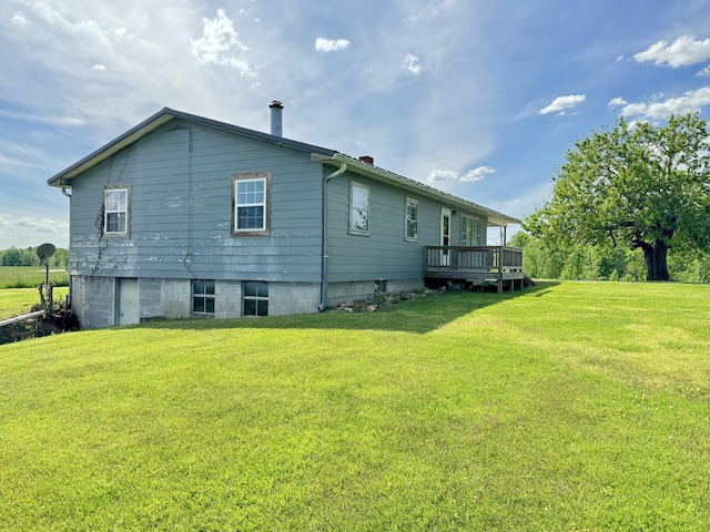 rear view of property with a deck and a lawn