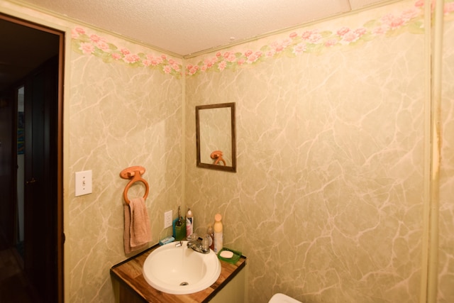 bathroom with a textured ceiling and vanity