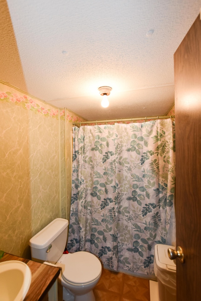 bathroom with sink, toilet, and a textured ceiling