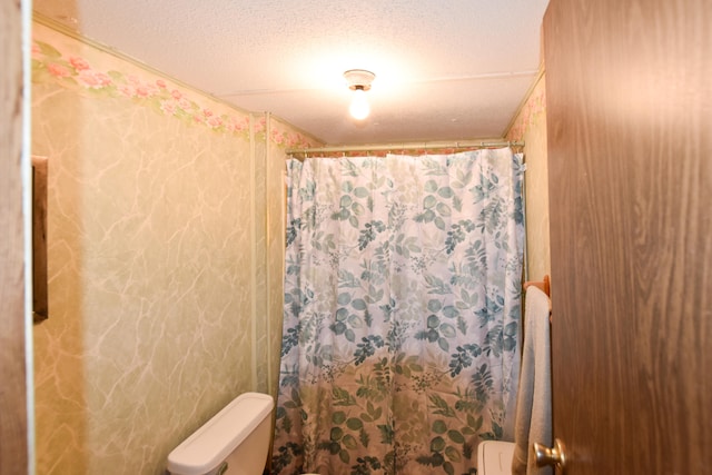 bathroom featuring a textured ceiling and toilet