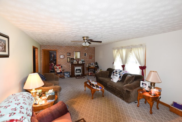 carpeted living room with brick wall, a textured ceiling, ceiling fan, and a fireplace