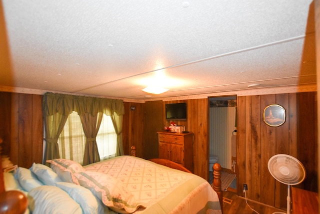 bedroom featuring wood walls and a textured ceiling